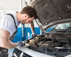 Image of Mechanic checking car engine